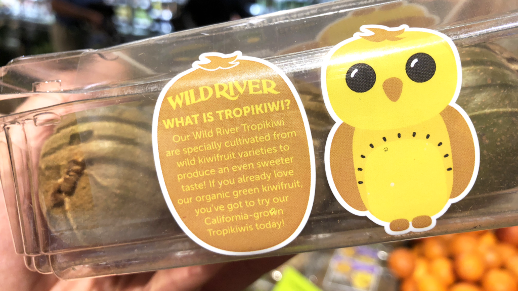 Our Owl Friends and associated kiwi owl logos are trademarks of Wild River Marketing Inc. Designed by Ben Young Landis and Guy Rogers. The photo shows the front side of a Wild River plastic clamshell container for kiwifruit. Next to a old kiwi owl, the text reads: What is Tropikiwi? Our Wild River Tropikiwi are specially cultivated from wild kiwifruit varieties to produce an even sweeter taste! If you already love our organic green kiwifruit, you've got to try our California-grown Tropikiwis today!