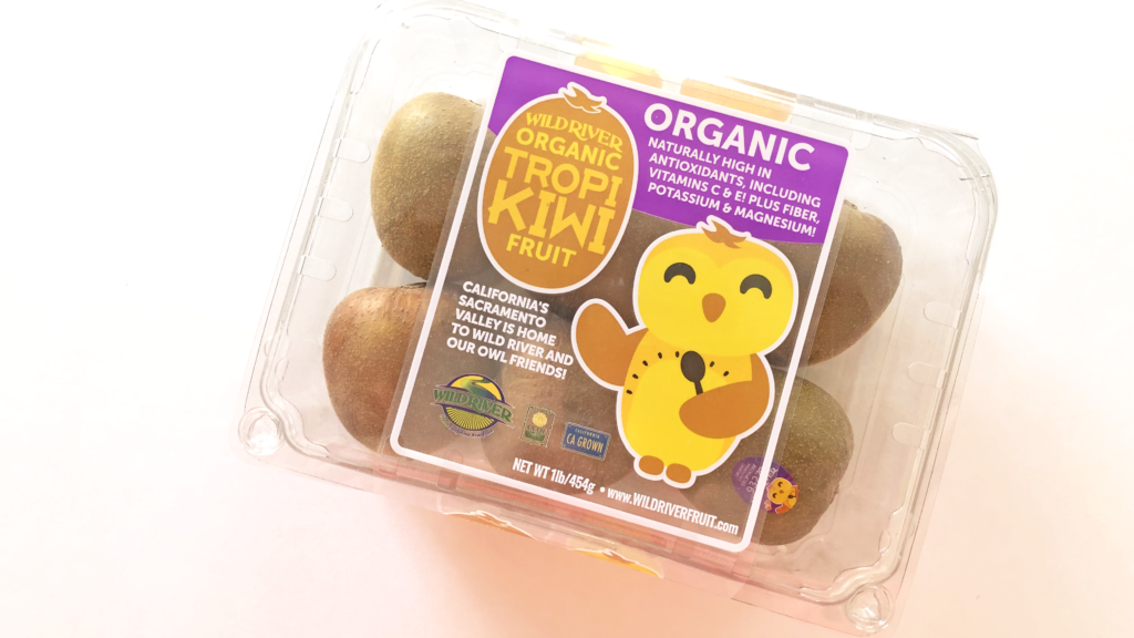 Our Owl Friends and associated kiwi owl logos are trademarks of Wild River Marketing Inc. Designed by Ben Young Landis and Guy Rogers. The photo shows a plastic clamshell container with six Tropikiwi kiwifruits inside. The container's graphic shows the smiling Wild River gold kiwi owl with one wing holding a spoon. Graphic says "California's Sacramento Valley is home to Wild River and Our Owl Friends!" and that the fruits are organic, naturally high in antioxidants, including vitamins C & E! Plus fiber, potassium & magnesium!